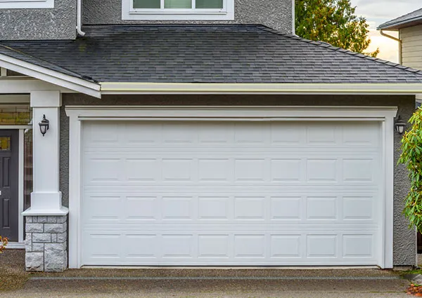 White garage door with a gray house exterior, relevant to childproofing a garage. A Grade Garage Doors, Perth