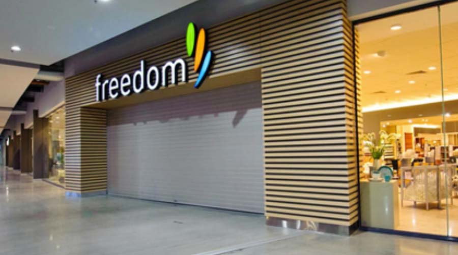 Freedom store with roller shutters closed, showcasing a modern storefront design in a shopping mall. A Grade Garage Doors, Perth