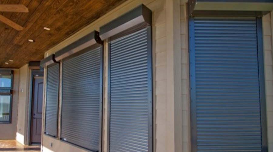 Exterior view of a building with gray roller shutters covering the windows. A Grade Garage Doors, Perth